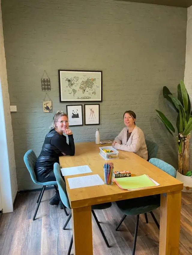 Twee coaches in gesprek aan tafel tijdens een praktijkdag coachen op interactievaardigheden